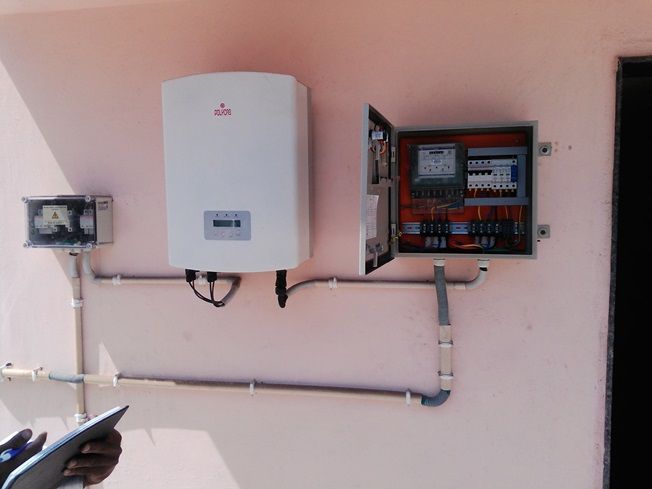 Grid-tied inverter beside its control and metering panel.