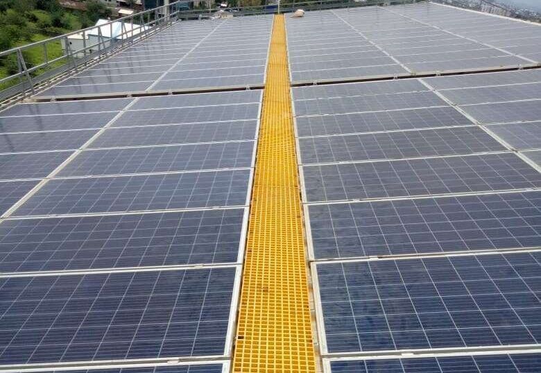 Completed rooftop solar array with a service walkway between the module rows.